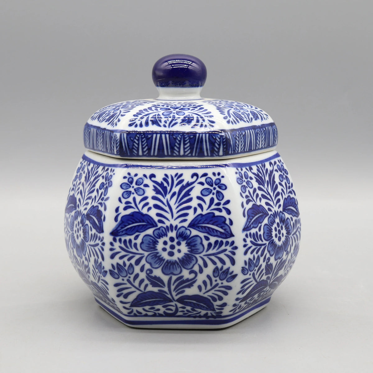 Pot de céramique décoratif orné de motifs floraux bleus et blancs.