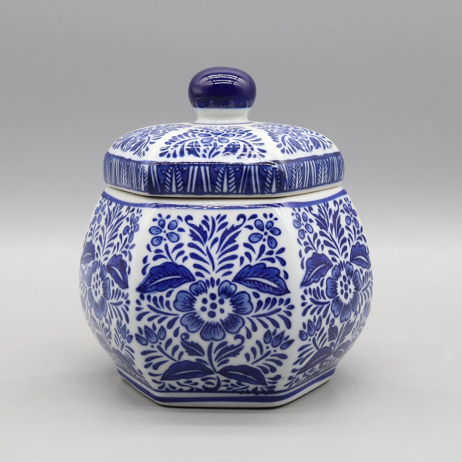 Pot de céramique décoratif orné de motifs floraux bleus et blancs.