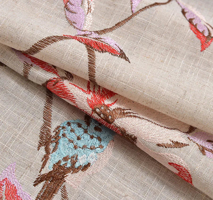 Tissu décoratif avec broderies colorées de fleurs et d'oiseaux, idéal pour la décoration intérieure et les projets créatifs. Élément élégant et raffiné pour apporter une touche unique à votre espace de vie. Design harmonieux et motifs riches qui attirent l'attention et ajoutent du caractère à votre environnement.