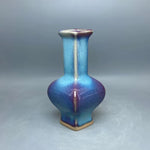 Vase de forme unique aux teintes bleutées irisées, créé avec des matériaux de haute qualité.