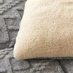Couverture lestée en fausse fourrure d'agneau noire avec des coussins assortis