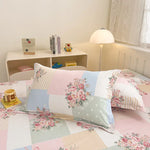 Chambre enfantine confortable avec des meubles beiges, des oreillers décorés de motifs floraux et une lampe ronde sur la table.