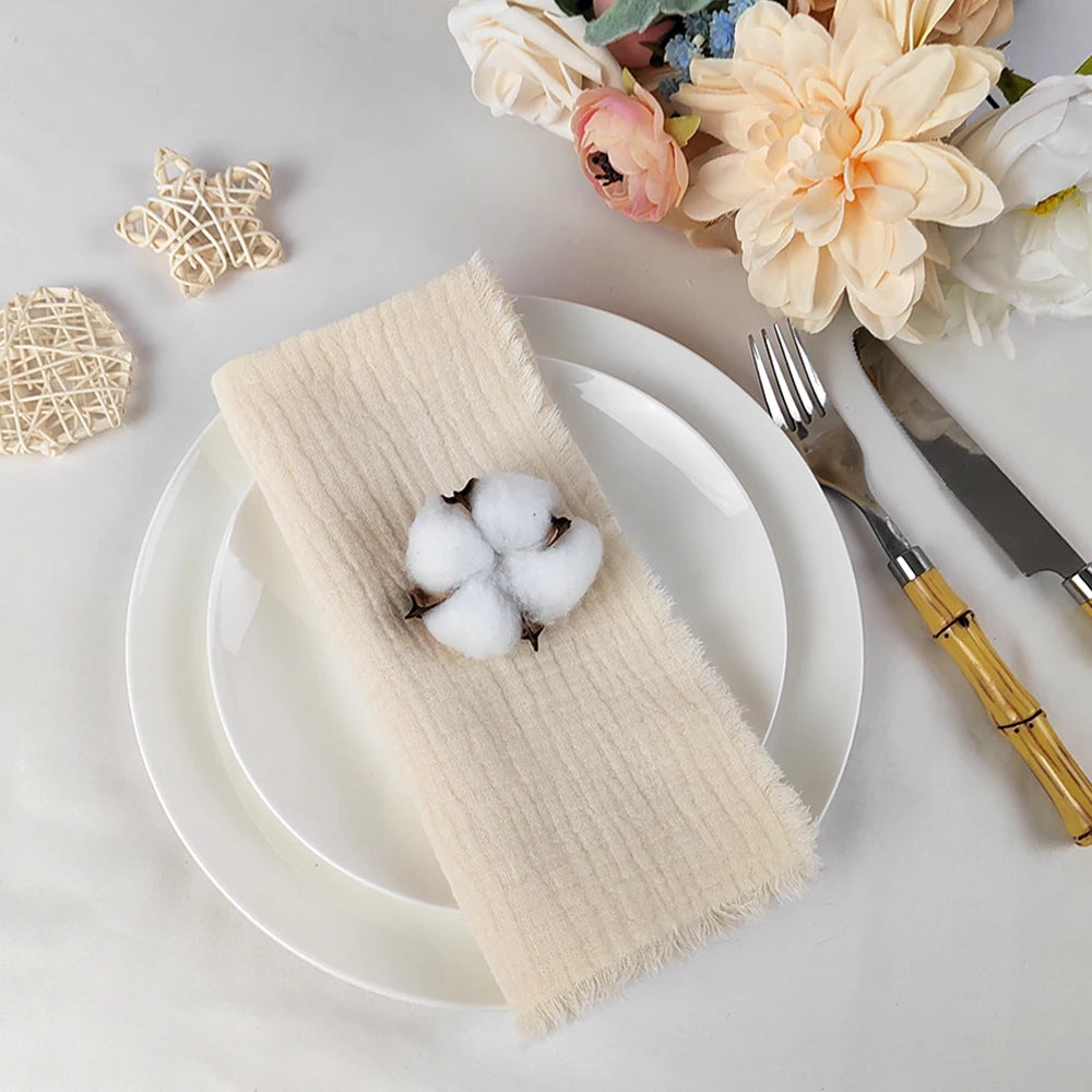 Une belle table dressée avec des fleurs élégantes, des décorations raffinées et des couverts dorés sur une nappe beige.