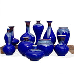 Magnifique collection de vases en céramique bleu foncé, présentant des formes et des textures variées, reflétant une sophistication et un style élégant.