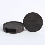 Ensemble de sous-verres ronds en bois foncé avec bords en cuir, empilés et prêts à être utilisés.