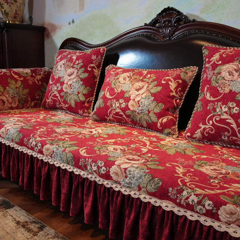 Ce canapé vintage au design baroque est recouvert d'un motif floral rouge et or, rehaussé de dentelle, offrant une atmosphère chaleureuse et élégante dans cet intérieur.
