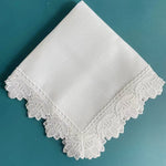 Un mouchoir en coton blanc avec un joli motif de dentelle sur les bords.