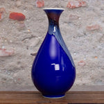 Un élégant vase en céramique bleu de style japonais.