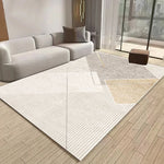 Un lumineux salon moderne avec un canapé gris, un tapis géométrique et une fenêtre donnant sur l'extérieur.