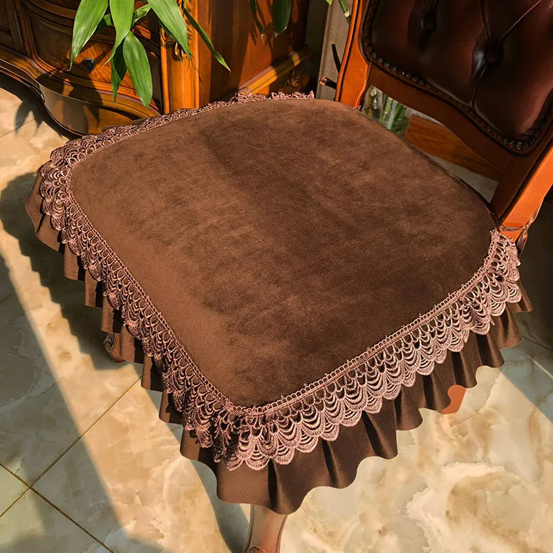 Coussins décoratifs ronds ornés de motifs élégants sur un canapé en bois foncé avec des plantes vertes dans un intérieur rustique.
