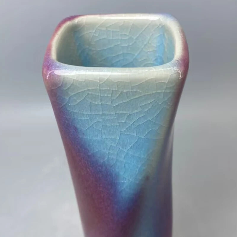 Vase décoratif en céramique avec un effet craquelé multicolore, aux tons de bleu, violet et rose, créant un design unique et artistique.