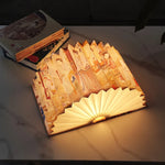 Lampe de chevet design en forme de livre posée sur table de nuit
