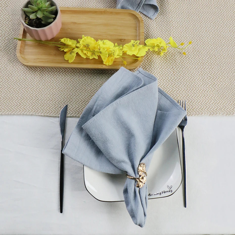 serviettes tissu pliées rustique bohème minimaliste liens anneaux couleurs beige rose vert bleu gris