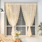 Voilage beige à motif dentelle installé sur une fenêtre à stores horizontaux, agrémenté d'une guirlande lumineuse, dans un intérieur chaleureux avec bouquet de marguerites.