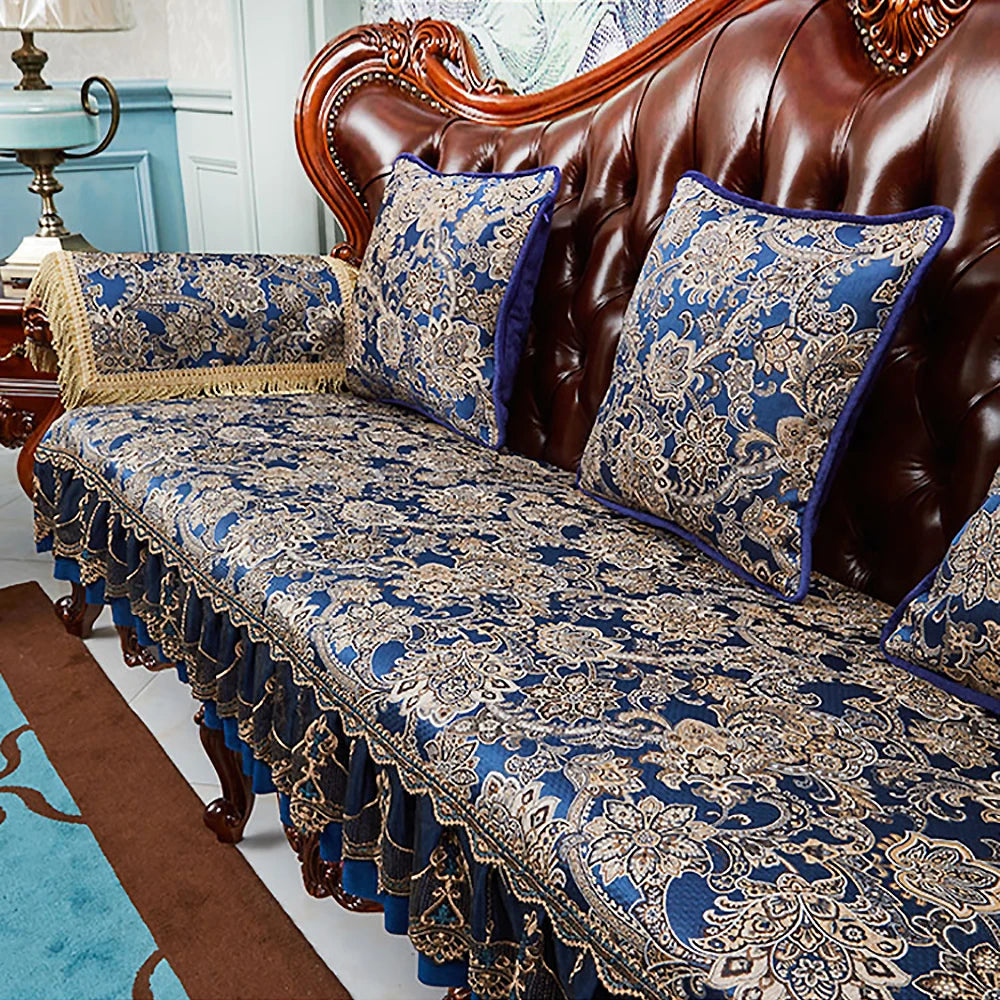Un canapé en cuir marron orné de coussins aux motifs floraux bleus et beiges, créant une atmosphère élégante et chaleureuse dans la pièce.
