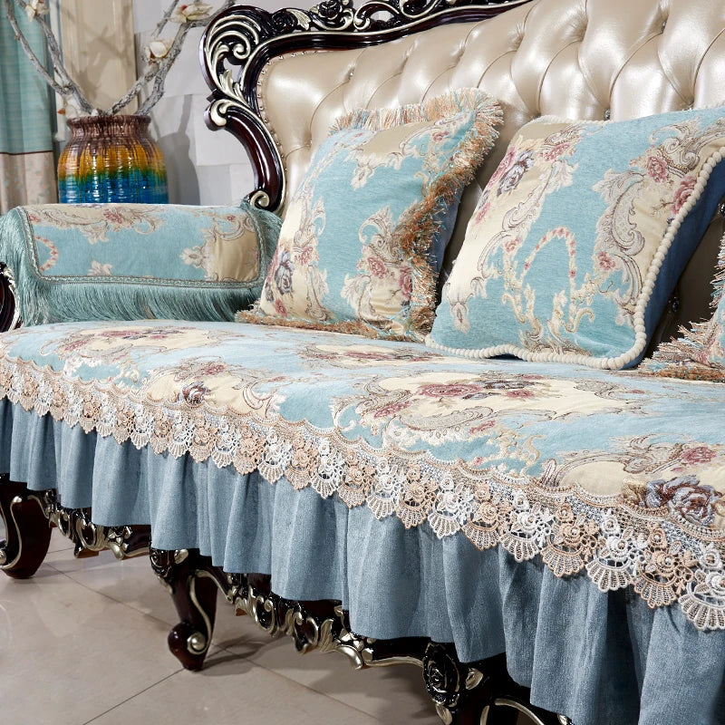 Un canapé vintage aux motifs floraux bleu ciel et beige, richement orné de dentelle et de détails sculptés, créant une ambiance chaleureuse et élégante.