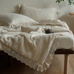 Couette d'été en gaze de coton et lin vert armée avec dentelle Jacquard sur un lit