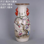 Vase en céramique de style oriental avec des motifs de fleurs et d'arbres colorés sur un fond craquelé blanc.