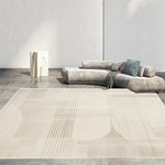 Le mobilier gris minimaliste et les tapis à motifs rayés créent une atmosphère épurée et moderne dans cette pièce.