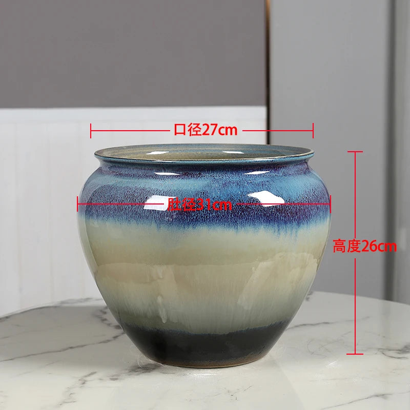 Pot de fleurs en céramique de forme ronde avec un motif de dégradé bleu et blanc, mesurant 27 cm de diamètre et 26 cm de hauteur.