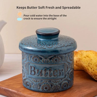 Beurrier à eau en céramique fleurie bleue sur table en bois