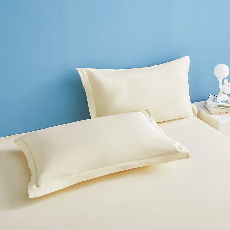 Deux oreillers blancs posés sur un lit bleu clair, créant une atmosphère sereine et reposante.