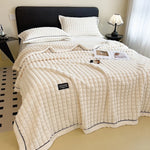 couverture double couche fausse fourrure beige rayures horizontales deux oreillers canapé