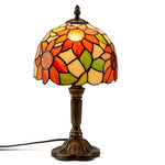 Lampe de chevet Tiffany dans une décoration chambre vintage avec textiles