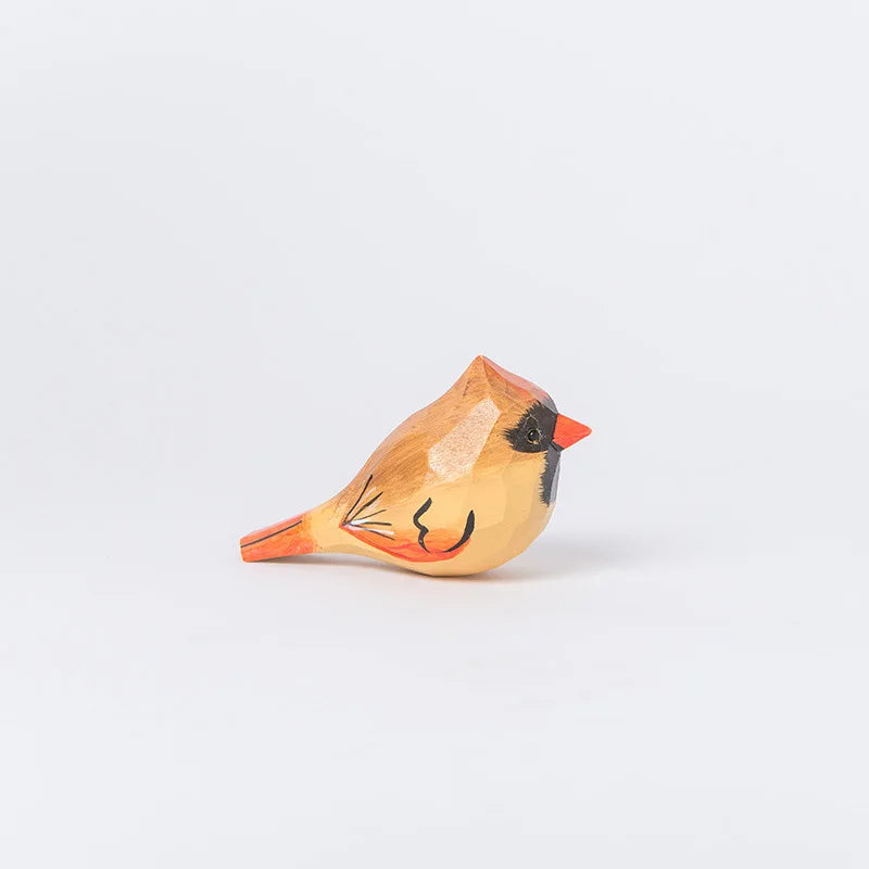 Une petite statuette en bois sculptée représentant un oiseau cardinal avec de belles couleurs ocre et rouges.