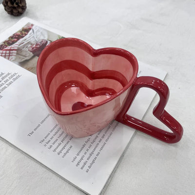Tasse à café en forme de cœur gris foncé sur fond blanc