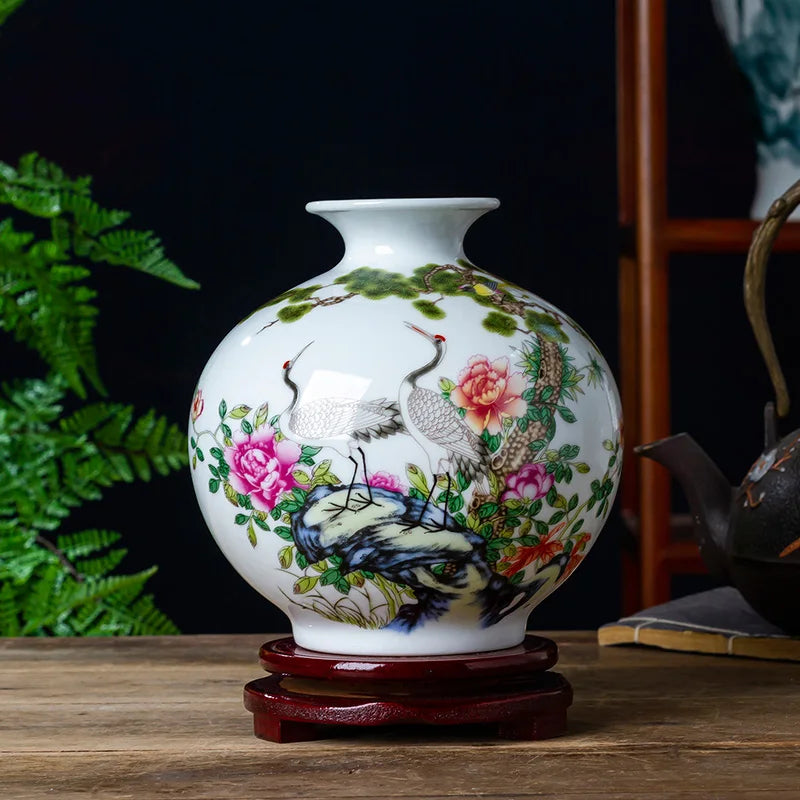 Magnifique vase en porcelaine blanche décoré de magnifiques grues, de fleurs roses épanouies et de verdure luxuriante, créant une scène naturelle apaisante.
