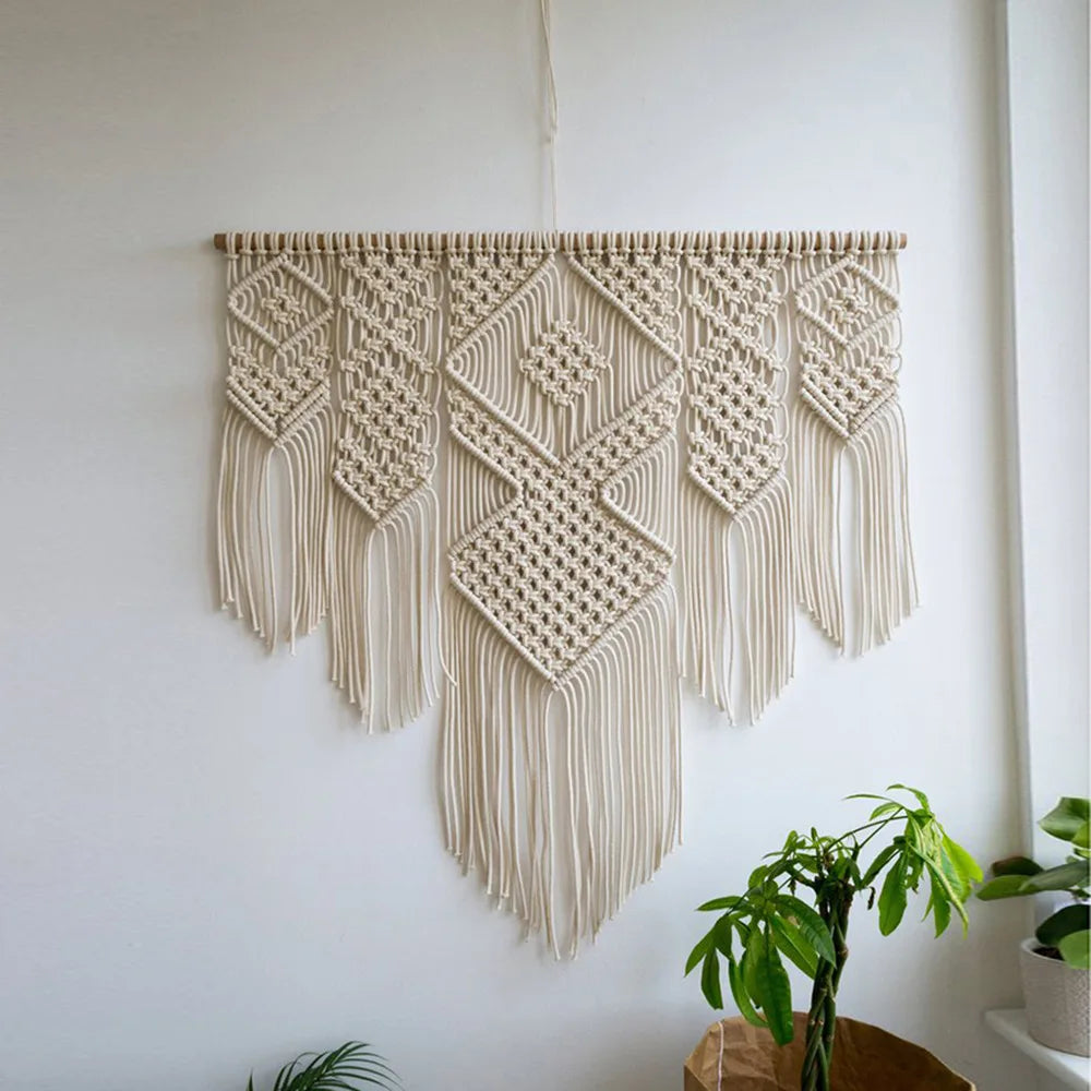 tapisserie macramé boho chic motifs géométriques franges beige clair tige bois crochets métalliques