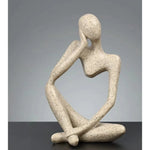statue décorative moderne figure humaine assise couleur or noir beige.texture granuleuse surface lisseintérieur moderne