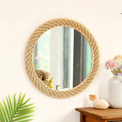 Miroir mural rond en rotin tissé main de couleur bronze sur un mur blanc