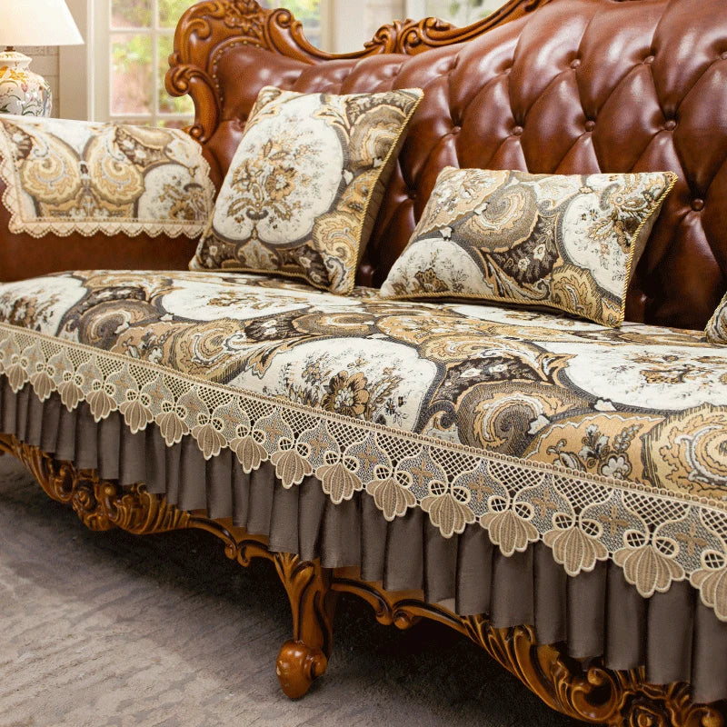 Un canapé en cuir brun richement décoré avec des coussins aux motifs floraux et une dentelle délicate sur le devant.