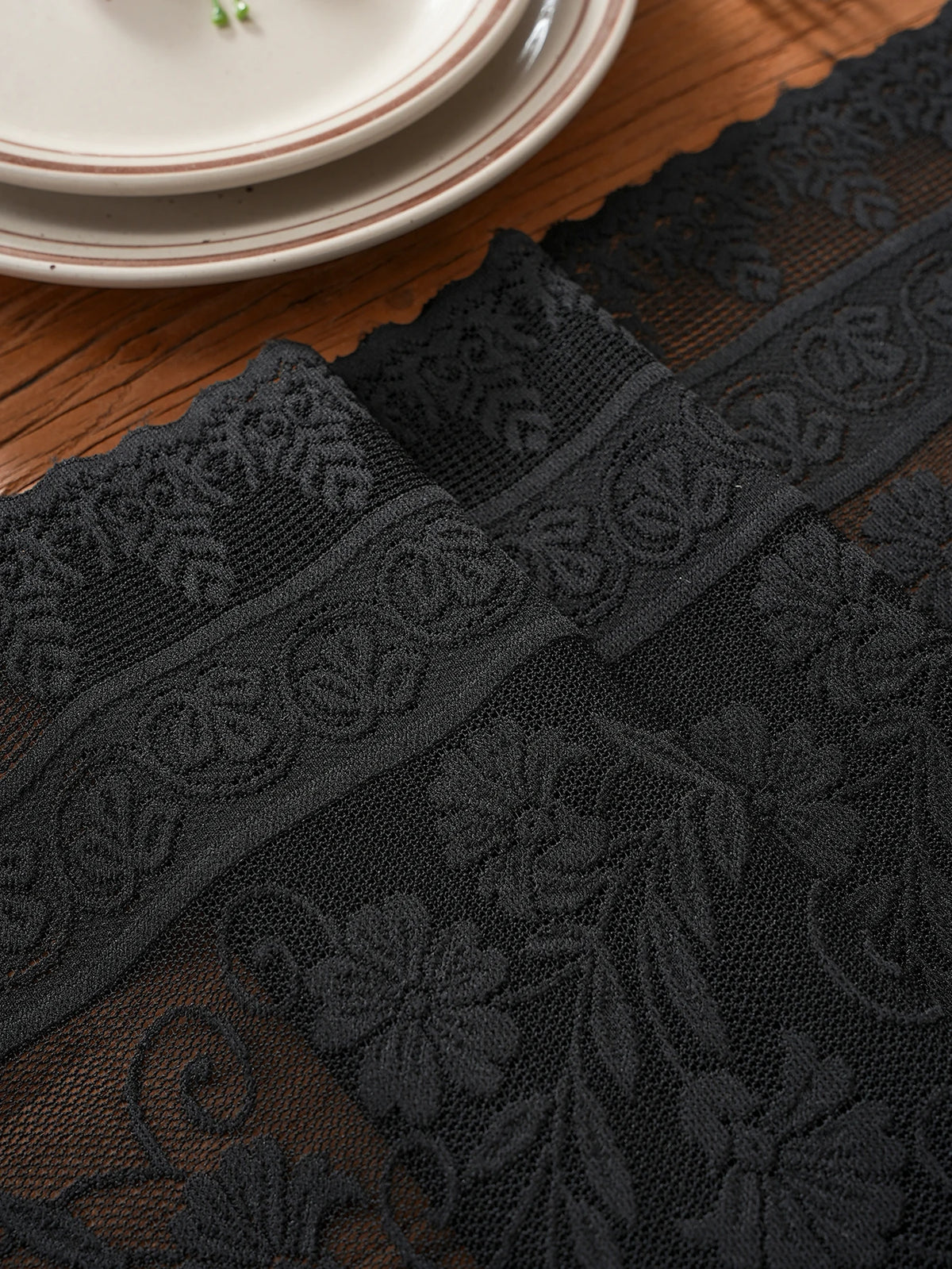 chimene table noir dentelle motif floral bordures franges assiettes couverts tasse théière gâteau cerises