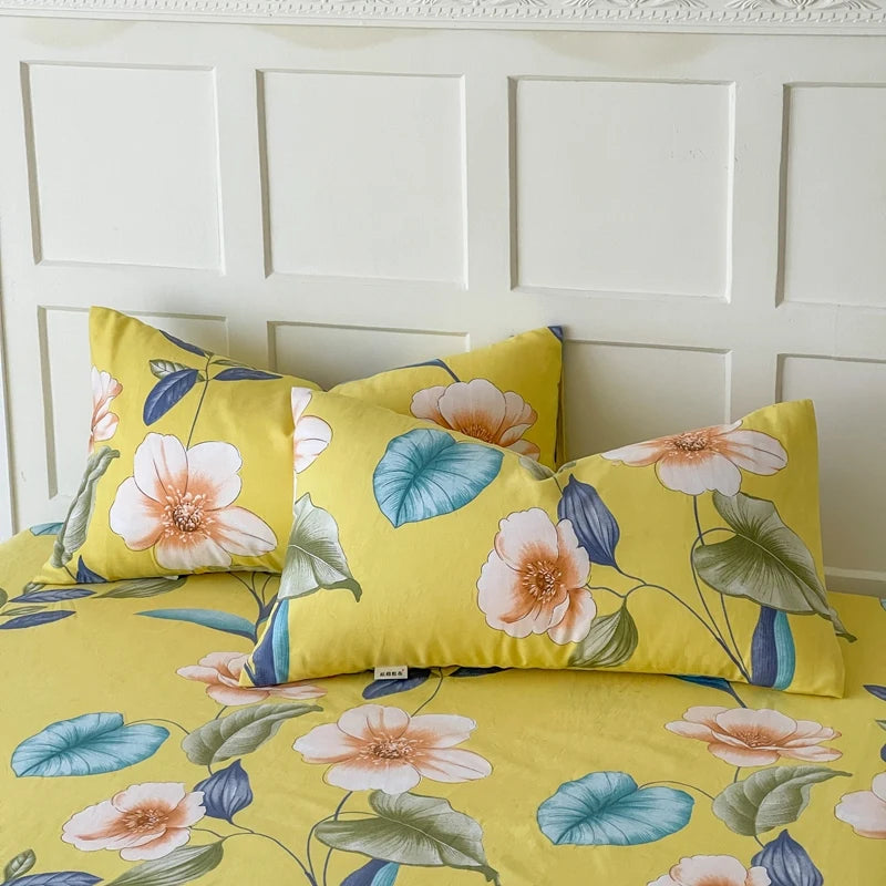 Parure de lit jaune vif ornée de grandes fleurs colorées et de feuilles vertes, créant un motif floral saisissant et enveloppant.