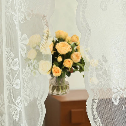 Rideau dentelle blanche avec bouquet de roses jaunes en arrière-plan
