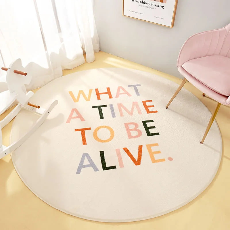 Décor de chambre avec un tapis rond et un texte "WHAT A TIME TO BE ALIVE" dans des couleurs vives sur un fond blanc.