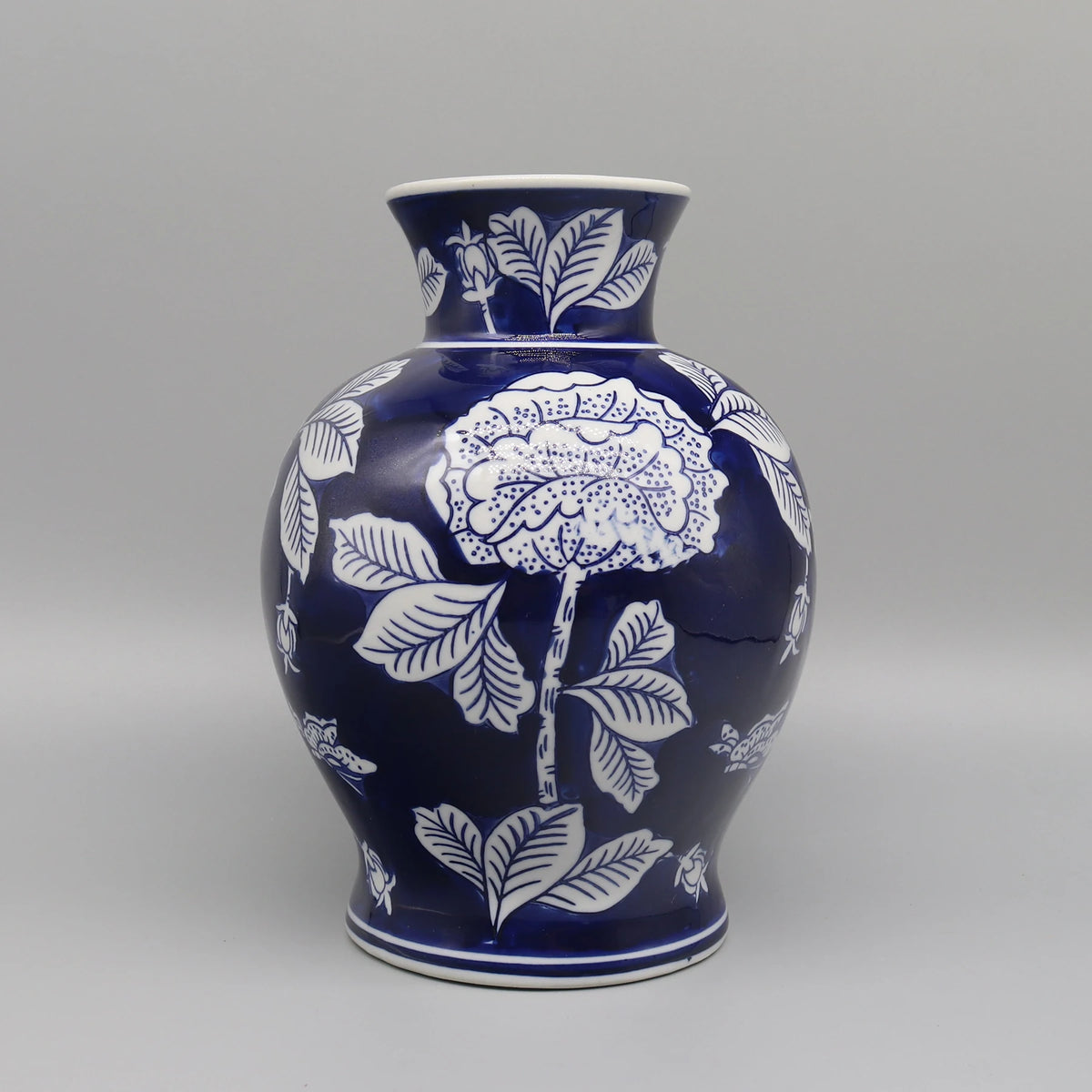 Vase en céramique bleu et blanc avec des motifs floraux élégants.