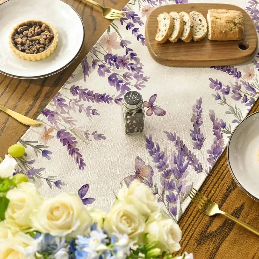 Élégant ensemble de vaisselle et de fleurs sur une nappe fleurie, reflétant une atmosphère raffinée et chaleureuse.