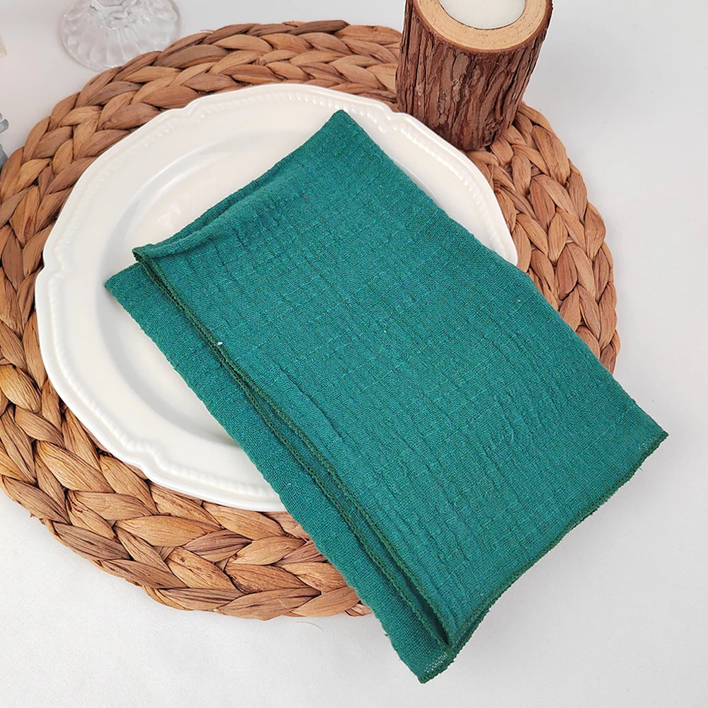 Un service de table en rotin tressé supportant une assiette blanche et un linge de table vert.