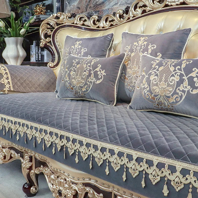 Canapé orné d'un design vintage avec des coussins décoratifs en gris et doré, dans un environnement intérieur luxueux.