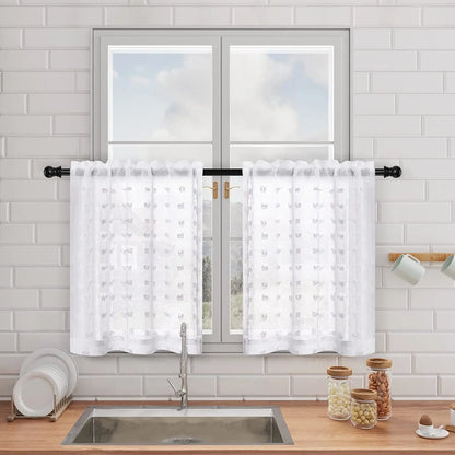 Voilages blancs courts à motifs discrets installés sur une fenêtre de cuisine, apportant de la lumière tout en préservant l’intimité.