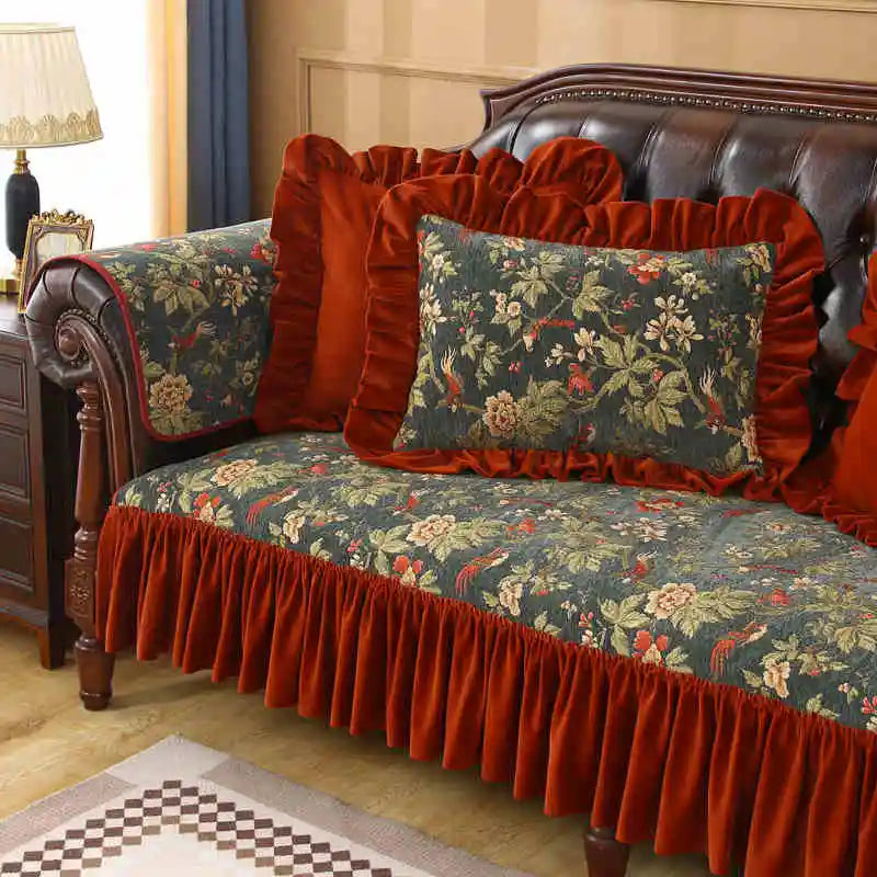 Le canapé rembourré de style rustique est recouvert d'un motif floral élégant avec des accents rouges vifs et des coussins assortis pour une atmosphère chaleureuse et confortable.