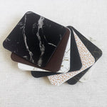 Ensemble de boîtes noires et blanches avec motifs décoratifs, représentant des étuis ou des accessoires pour appareils électroniques.
