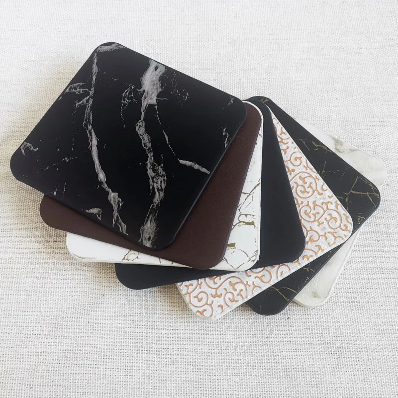 Ensemble de boîtes noires et blanches avec motifs décoratifs, représentant des étuis ou des accessoires pour appareils électroniques.