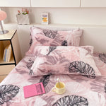 Joli ensemble de literie rose avec des motifs de feuilles tropicales imprimés, créant une ambiance cosy et relaxante dans la chambre.