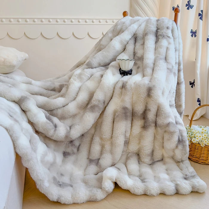 Une couverture douillette et moelleuse en fourrure blanche, ornée d'un nœud papillon noir élégant, crée une atmosphère cocooning dans cette pièce délicatement décorée.