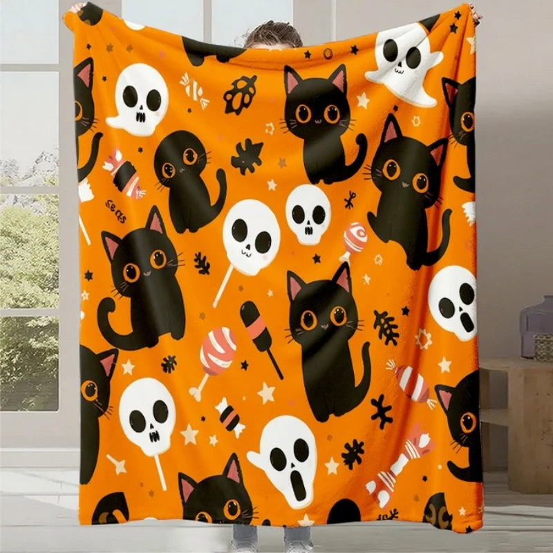 Couverture à motif orange vif ornée de silhouettes de chats noirs, d'os et de fantômes blancs, formant un design festif et amusant pour l'Halloween.